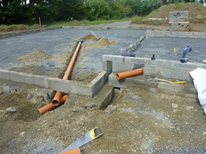 Проведение канализационной системы под фундаментом плиточного типа